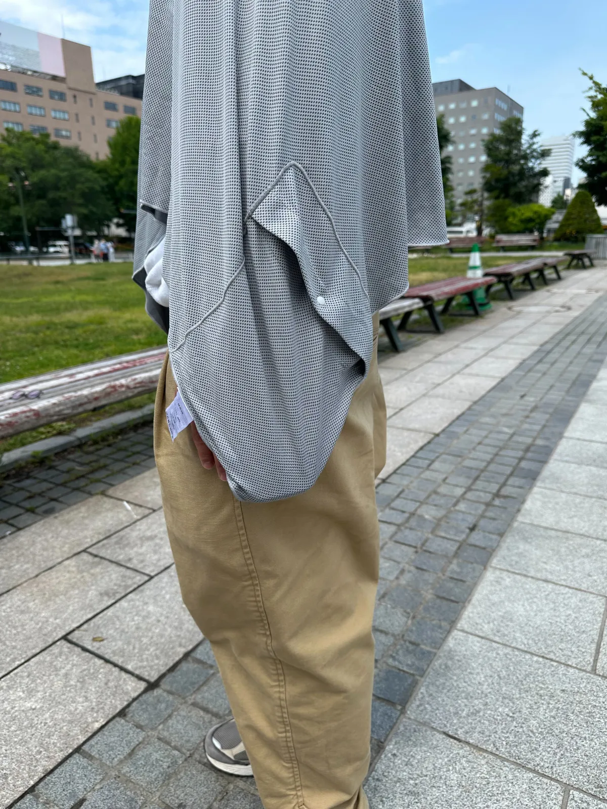 シックスパッド 冷感フードポンチョのポケットにスマホを入れている様子